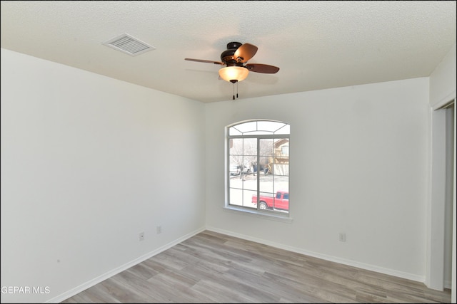 unfurnished room featuring ceiling fan, light hardwood / wood-style floors, and a textured ceiling