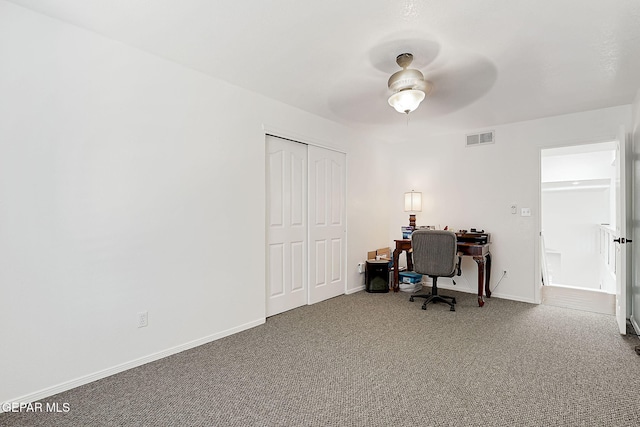 carpeted office space featuring ceiling fan