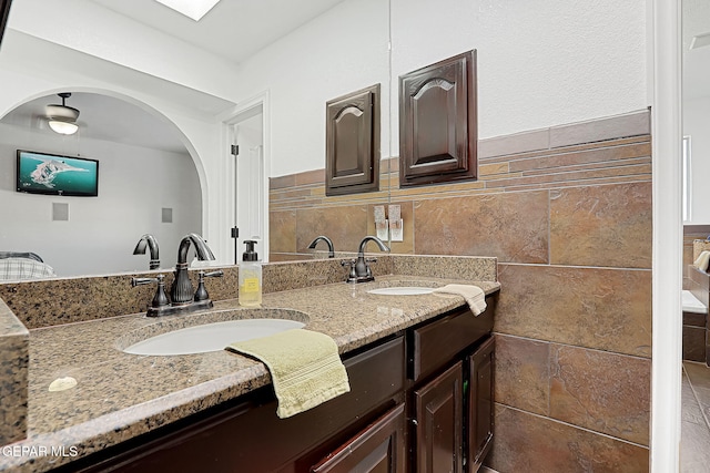 bathroom with vanity and tile walls