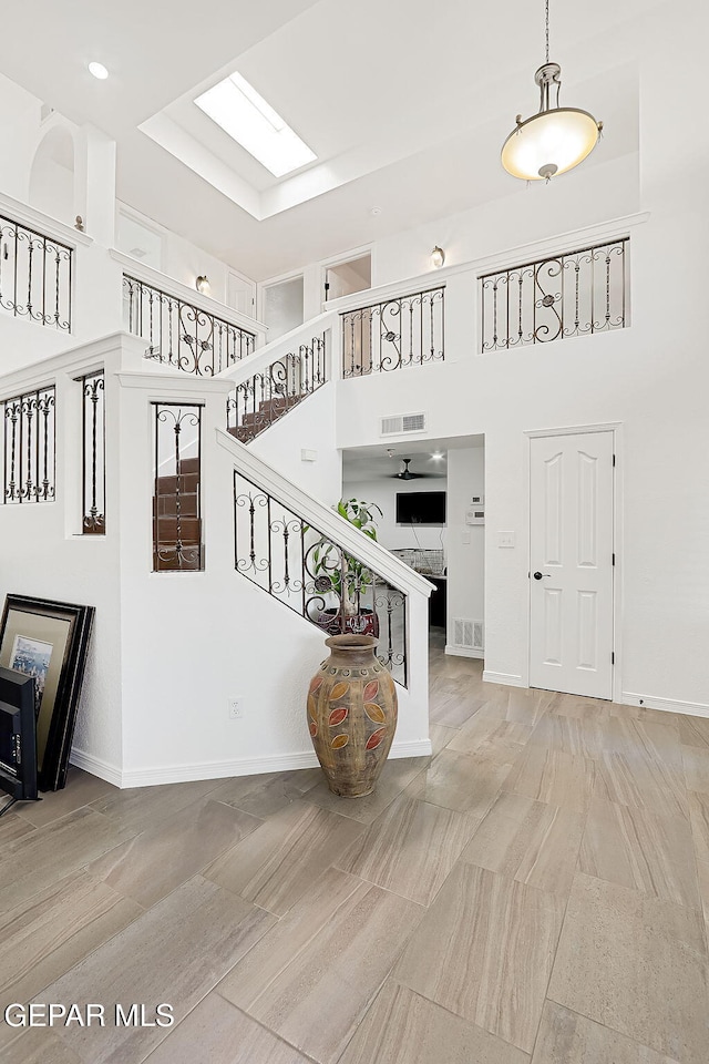 interior space featuring a skylight and a high ceiling