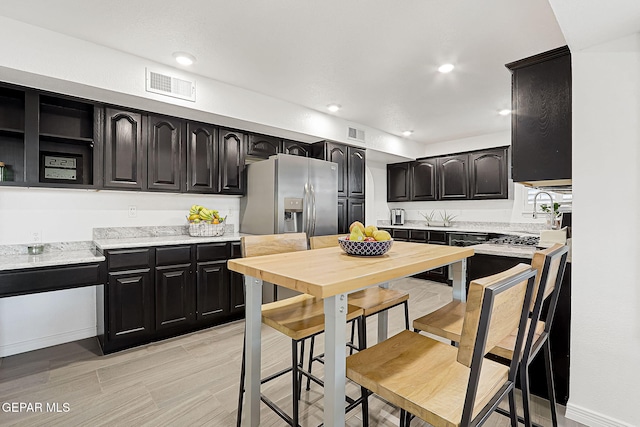 kitchen featuring sink and stainless steel refrigerator with ice dispenser