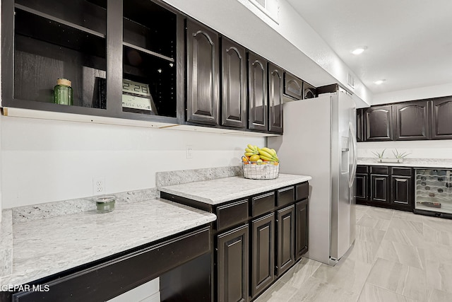 kitchen featuring stainless steel refrigerator with ice dispenser, dark brown cabinets, and wine cooler