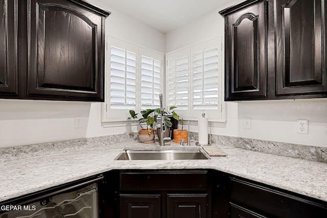 kitchen featuring dishwashing machine, sink, and dark brown cabinets