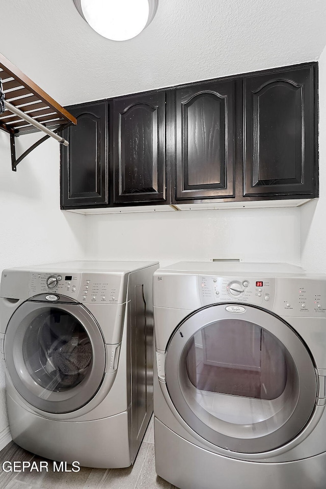 laundry area featuring cabinets and washing machine and clothes dryer