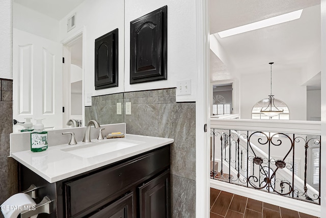 bathroom with vanity, hardwood / wood-style floors, and tile walls