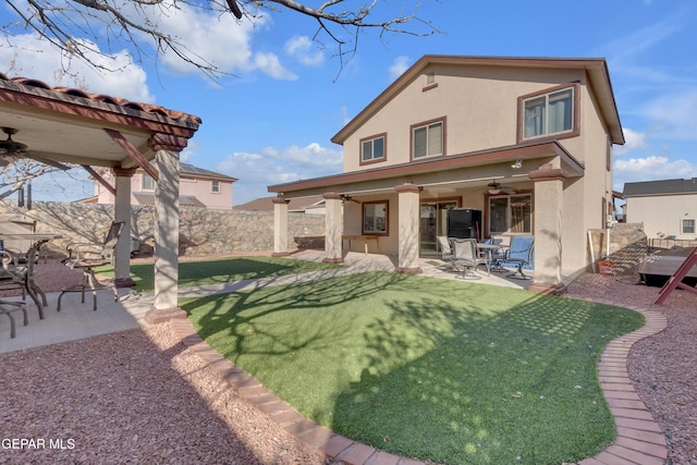 back of property with a patio area, ceiling fan, and a lawn