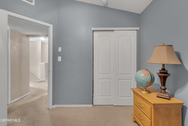 bedroom featuring a closet, light carpet, and a textured ceiling