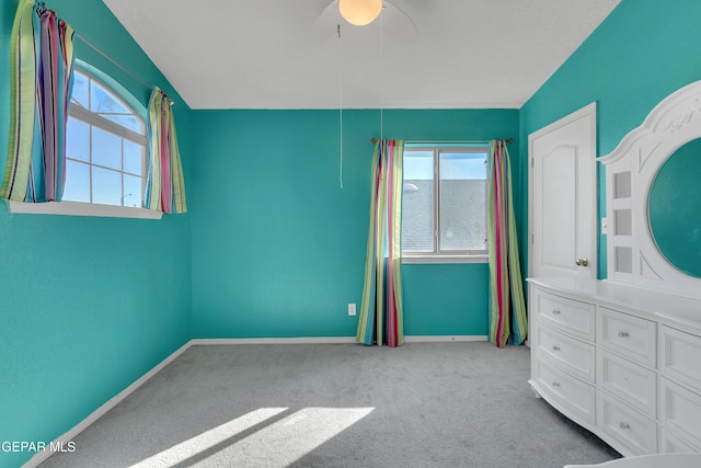 unfurnished bedroom with ceiling fan, light colored carpet, and multiple windows