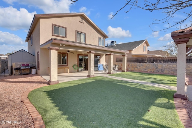 rear view of property featuring a patio, a yard, and ceiling fan