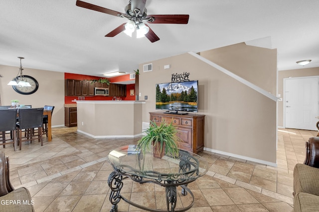 tiled living room featuring ceiling fan and sink