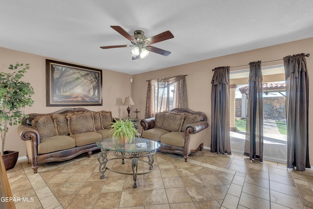 living room featuring a textured ceiling and ceiling fan