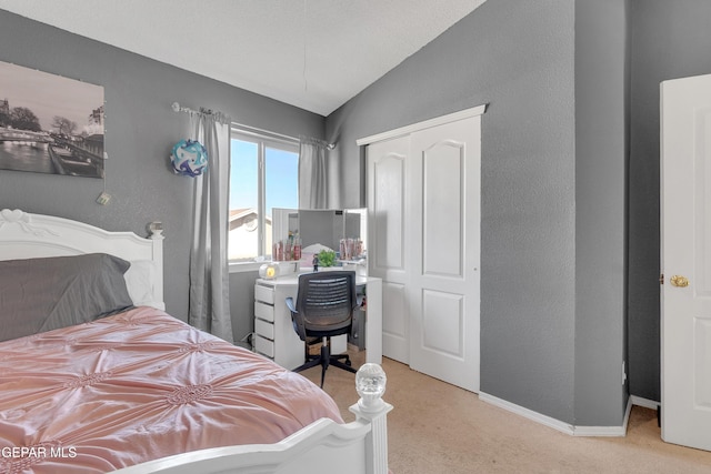 carpeted bedroom featuring lofted ceiling and a closet