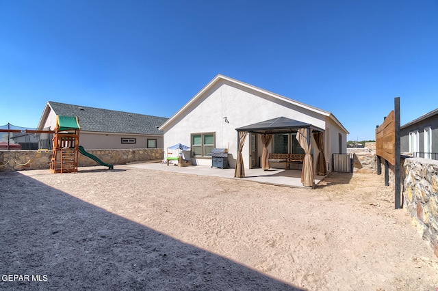 rear view of house with a playground and a patio area