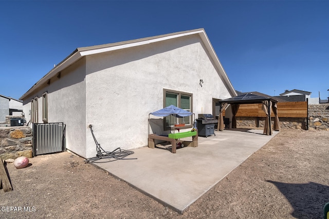 back of property featuring a gazebo and a patio