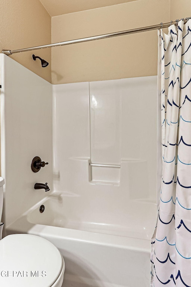 bathroom featuring shower / bath combo and toilet