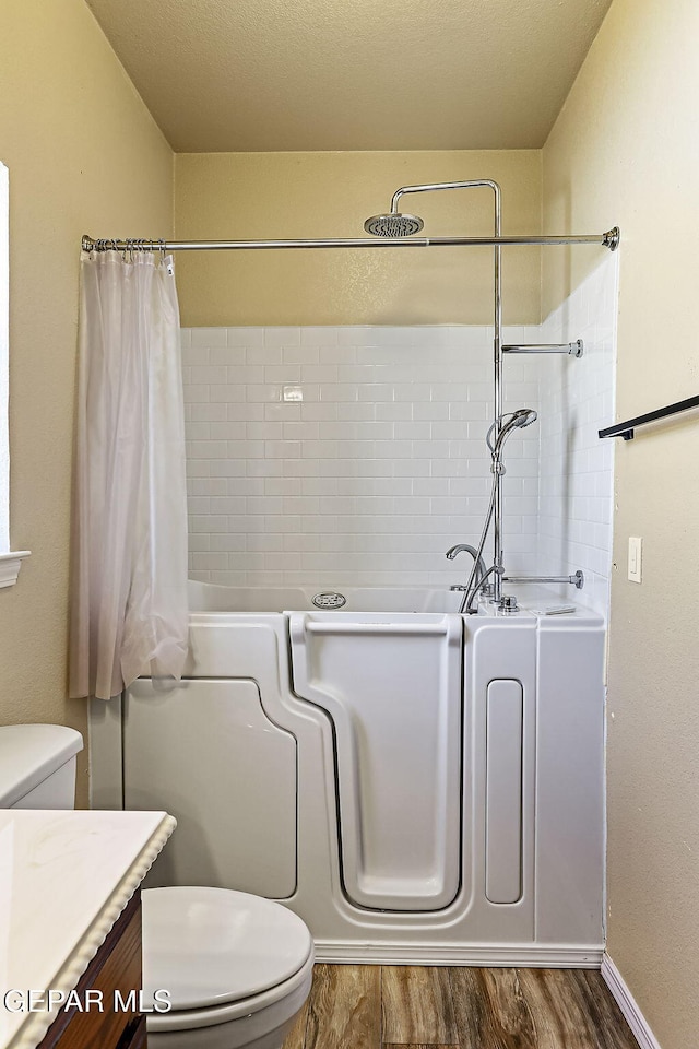 bathroom featuring vanity, a bathtub, hardwood / wood-style flooring, and toilet