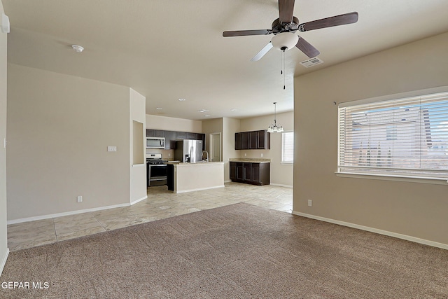 unfurnished living room with ceiling fan with notable chandelier and light colored carpet