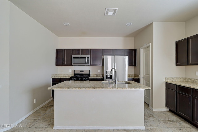 kitchen featuring appliances with stainless steel finishes, sink, an island with sink, and dark brown cabinets