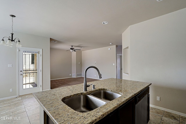 kitchen featuring decorative light fixtures, dishwasher, sink, light stone countertops, and a center island with sink