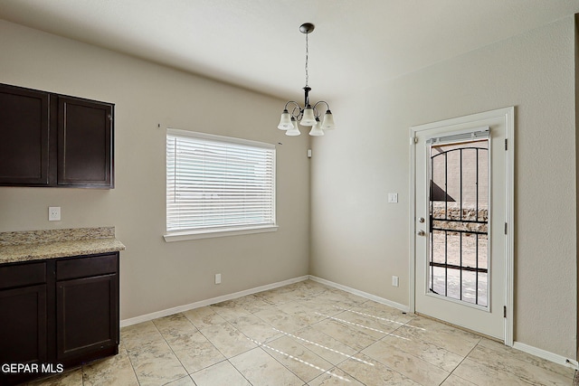 unfurnished dining area featuring a chandelier