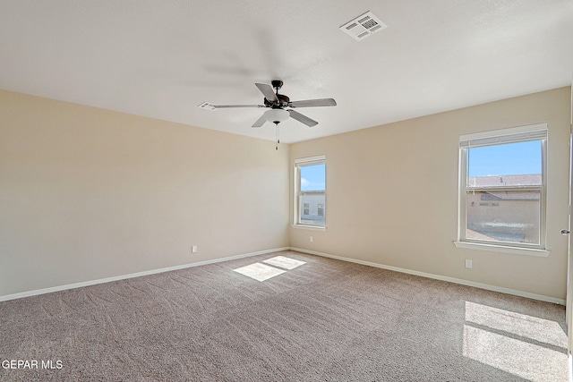 spare room with plenty of natural light, ceiling fan, and carpet flooring