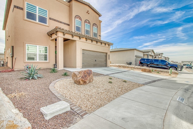 view of front of property featuring central AC unit and a garage