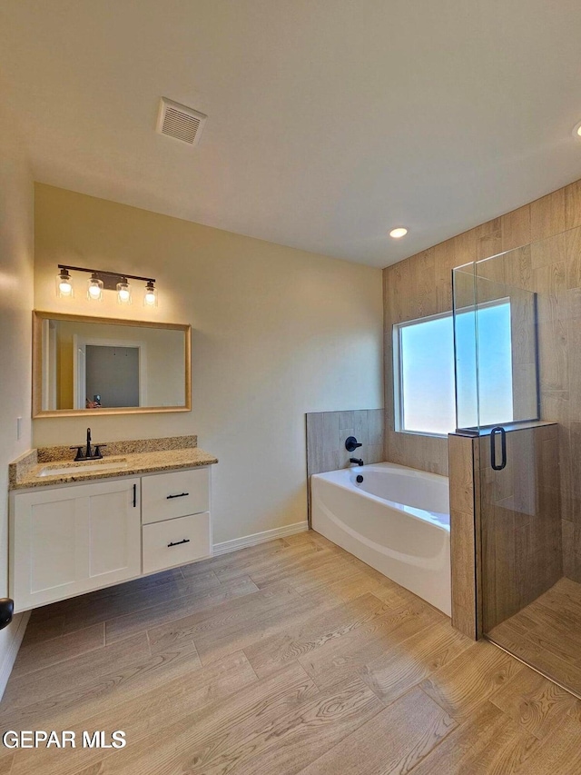 bathroom featuring wood-type flooring, separate shower and tub, and vanity