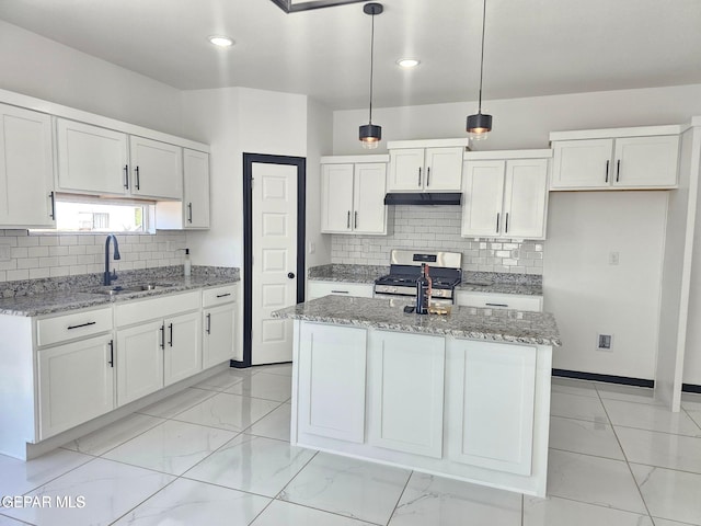 kitchen with pendant lighting, an island with sink, sink, white cabinets, and stainless steel range with gas stovetop