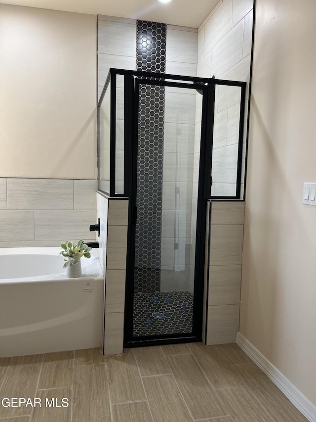 13345 Emerald Pearl Dr, Horizon City, TX 79928 - full bath featuring a shower stall, a bath, baseboards, and wood tiled floors