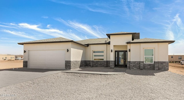 prairie-style home featuring a garage, stone siding, concrete driveway, and stucco siding