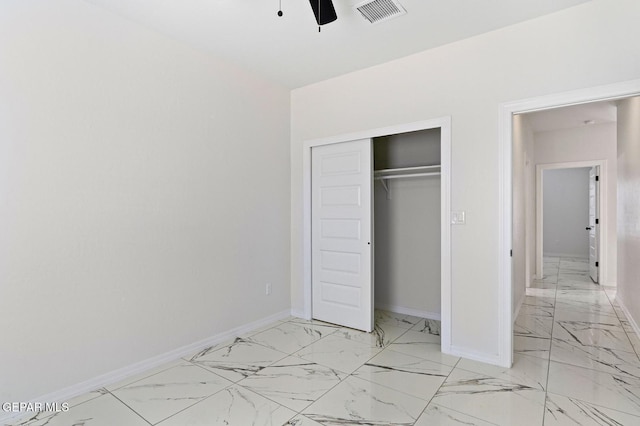 unfurnished bedroom with marble finish floor, a closet, visible vents, a ceiling fan, and baseboards