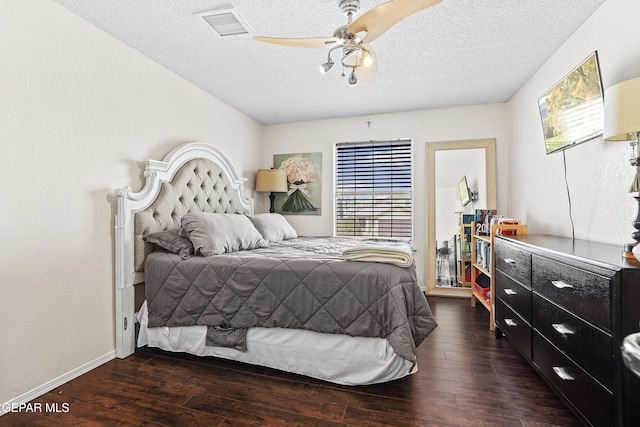 bedroom with dark hardwood / wood-style flooring, ceiling fan, and a textured ceiling