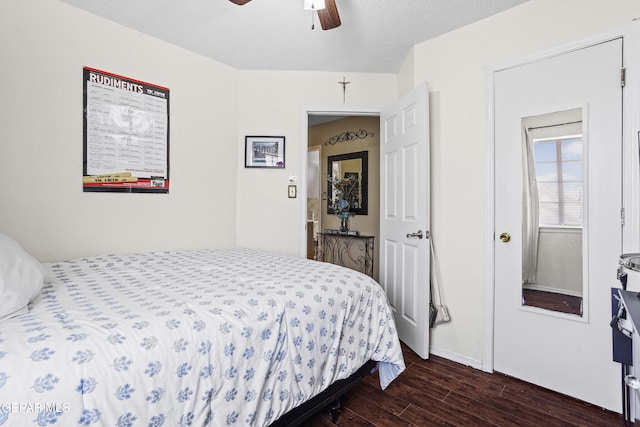 bedroom with ceiling fan, dark hardwood / wood-style floors, and a textured ceiling