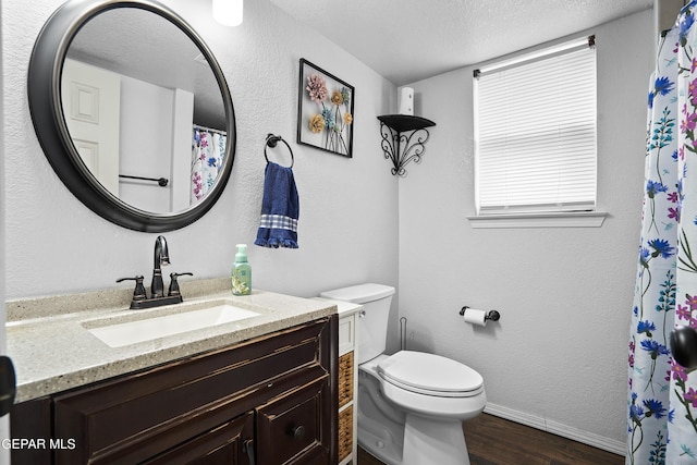 bathroom featuring vanity, hardwood / wood-style floors, a textured ceiling, and toilet