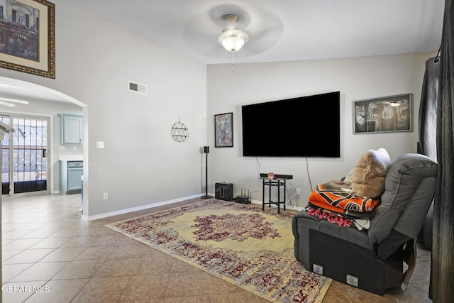 living room featuring lofted ceiling, tile patterned floors, and ceiling fan