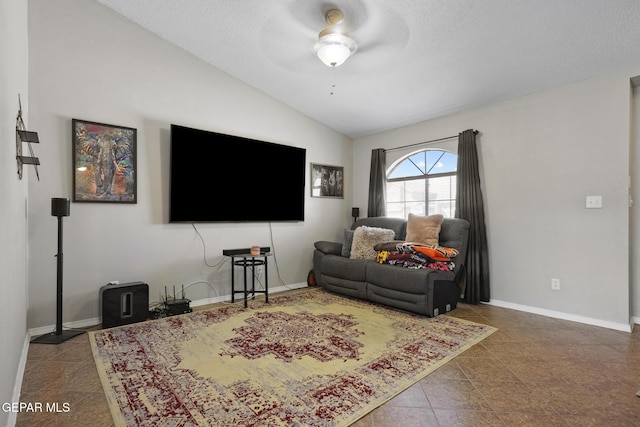 tiled living room featuring ceiling fan and vaulted ceiling