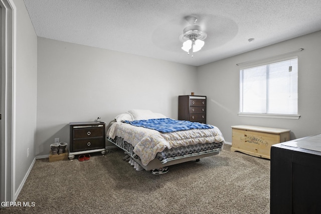 carpeted bedroom featuring ceiling fan and a textured ceiling