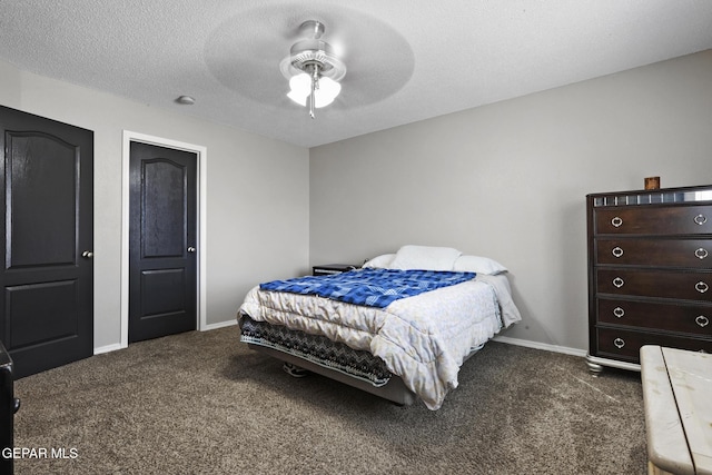 bedroom with ceiling fan, dark carpet, and a textured ceiling