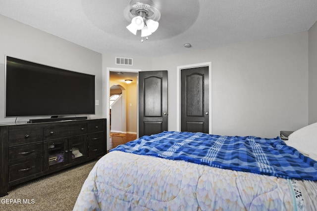 bedroom featuring ceiling fan, a textured ceiling, and carpet flooring