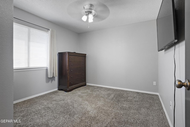 unfurnished bedroom with ceiling fan, carpet floors, and a textured ceiling