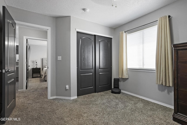 carpeted bedroom with a closet and a textured ceiling