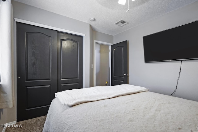 bedroom featuring ceiling fan, carpet, a textured ceiling, and a closet