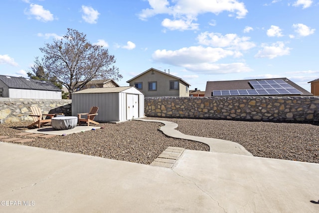 view of yard featuring a patio, a storage unit, and a fire pit