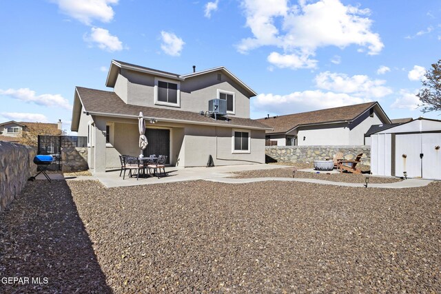 rear view of house featuring a shed, cooling unit, and a patio area