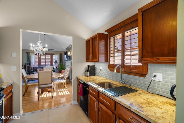 kitchen featuring vaulted ceiling, decorative light fixtures, dishwasher, sink, and light tile patterned floors