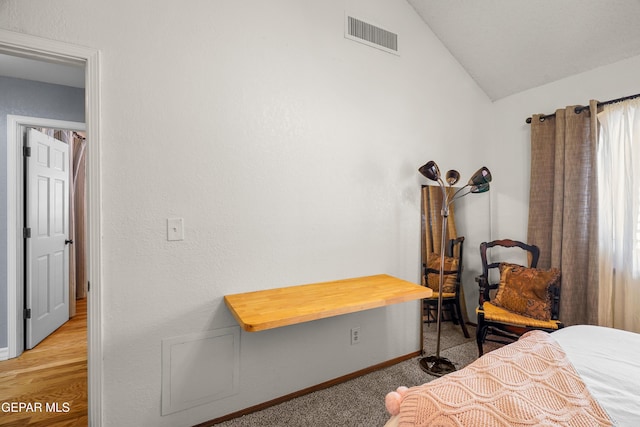 bedroom featuring vaulted ceiling and light colored carpet