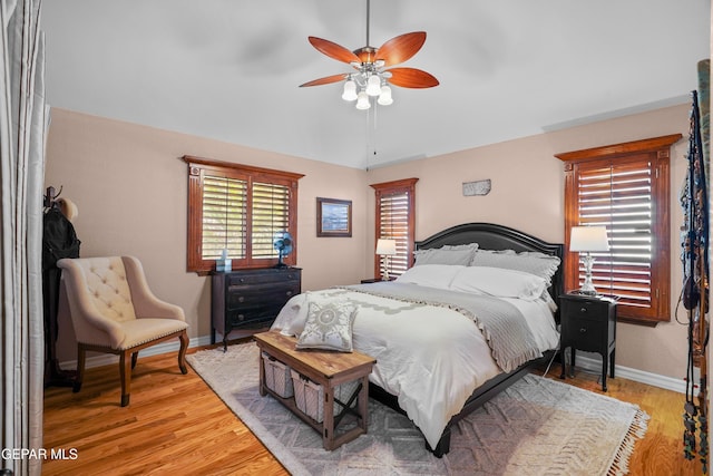 bedroom with vaulted ceiling, ceiling fan, and light wood-type flooring