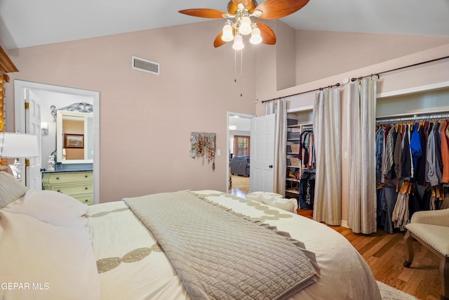 bedroom with multiple closets, ceiling fan, high vaulted ceiling, and light hardwood / wood-style flooring