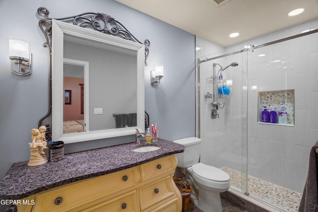 bathroom with walk in shower, vanity, and toilet