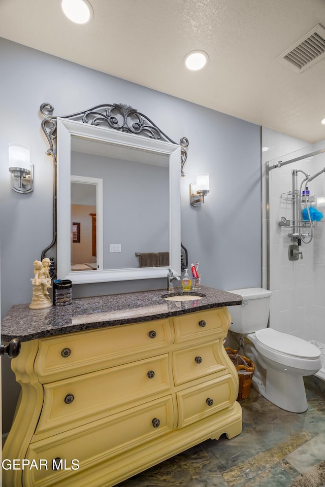 bathroom with vanity, a shower with door, and toilet